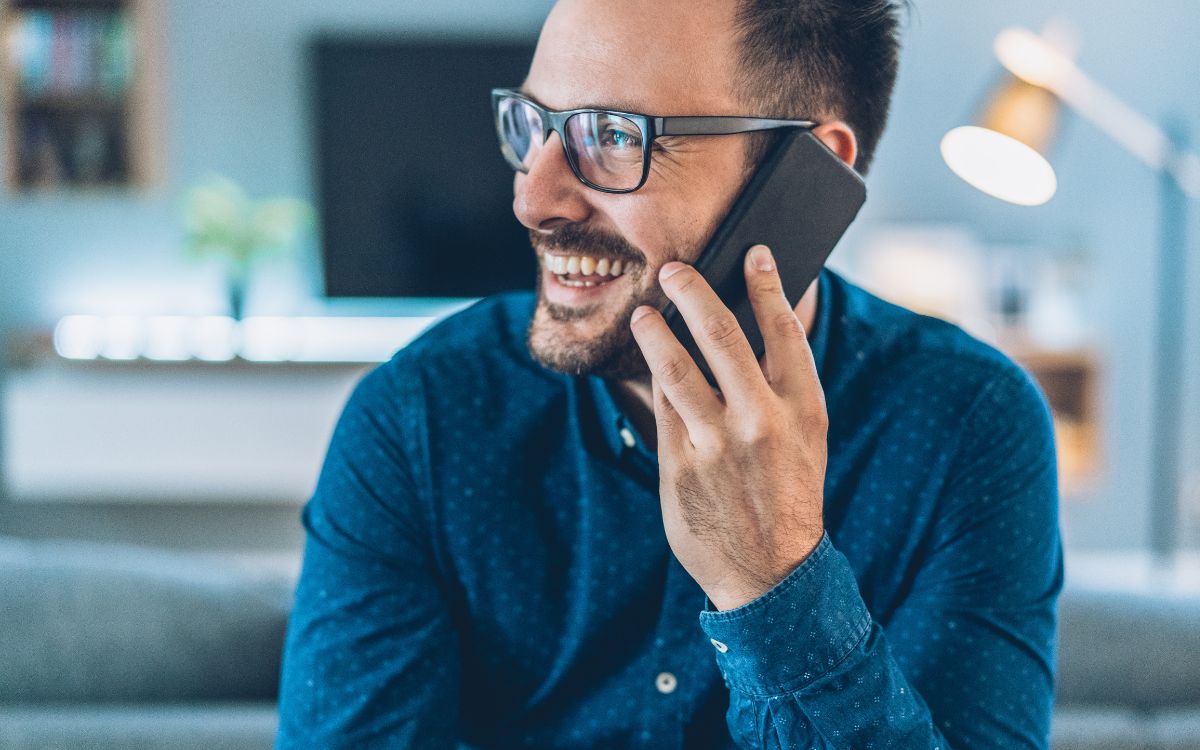A man smiling while on the phone